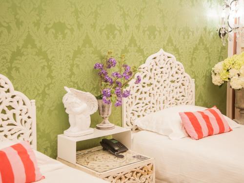 a bedroom with two white beds and a green wall at Anna King Hotel in Chiayi City