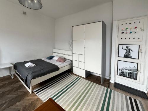 um quarto com uma cama, um armário e um tapete em Apartament przy Rotundzie em Varsóvia