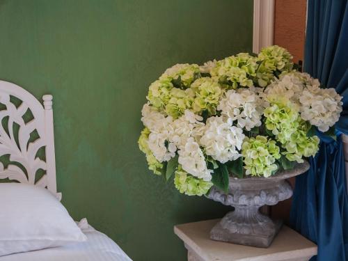 a vase filled with white and green flowers in a bedroom at Anna King Hotel in Chiayi City