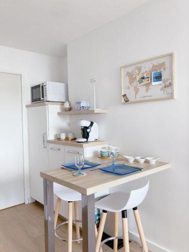 Il comprend une cuisine équipée d'une table avec deux chaises et d'un four micro-ondes. dans l'établissement Nouveau * Ty Lévenez *pour 2 vacanciers * Parking, à Carnac