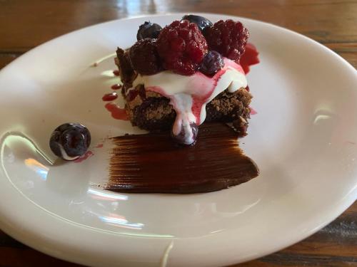 a piece of cake with berries on a white plate at Estancia La violeta in Chajarí