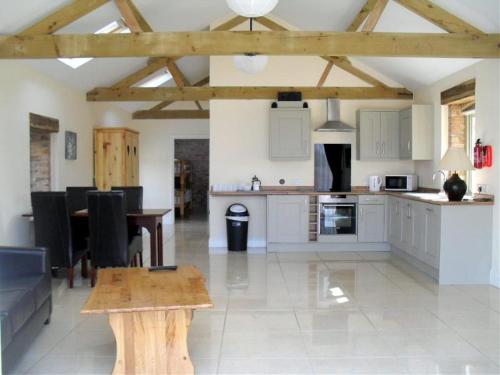a kitchen and living room with a table and a dining room at Foxes Den at Tove Valley Cottages in Towcester