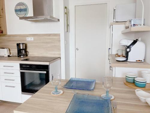 a kitchen with two wine glasses on a counter at Nouveau * Ty Lévenez *pour 2 vacanciers * Parking in Carnac