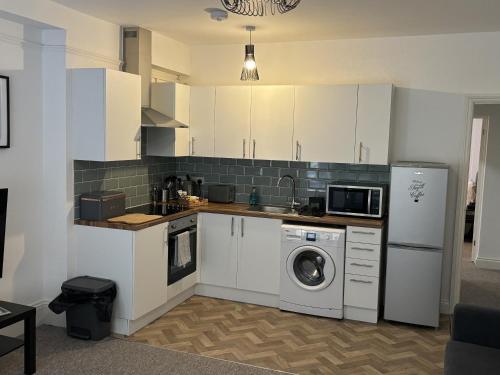 a kitchen with white cabinets and a washing machine at Urban Living - Flat 2 in Bournemouth