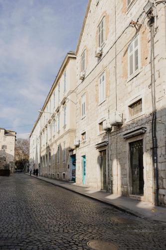 an empty street next to a large brick building at PIAC Luxury Suites in Split