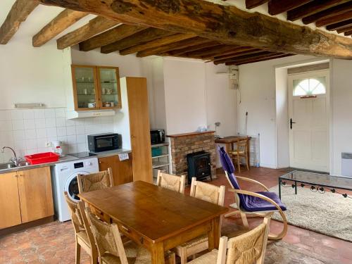 cocina y comedor con mesa de madera y sillas en Chateau de Bellefontaine, 