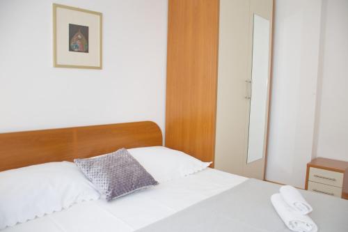 a bedroom with a white bed with two towels on it at Apartment MiraMar in Novalja
