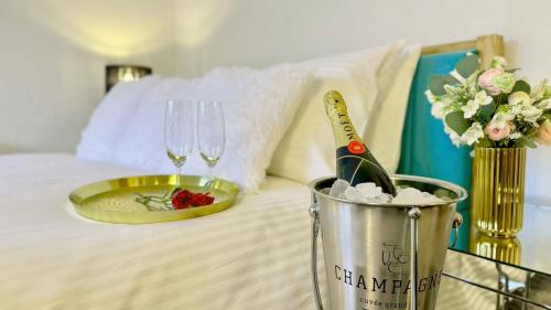 a bottle of champagne and a plate and glasses on a bed at Holidays by the beach are good for your soul and Seaview Palms is a lovely Devon seaside home make it yours for a romantic break or family adventure with private parking outdoor terrace village centre with a fab gastro pub shops and restaurant 120 reviews in Stoke Fleming