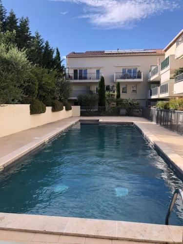 une grande piscine devant un immeuble dans l'établissement Studio Villa Serena piscine centre ville, à Saint-Rémy-de-Provence