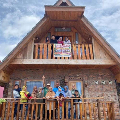 un grupo de personas de pie en un balcón de un edificio en Villa Cemara Siosar, en Kabanjahe