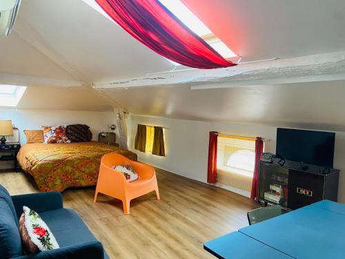 - une chambre avec un lit, un canapé et une télévision dans l'établissement Spacieux Studio Seventies: voyage dans le temps, à Gannat