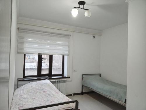 um quarto com 2 camas e uma janela em Mairambek em Kochkorka