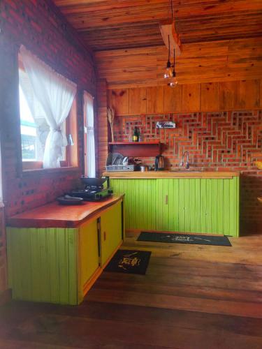 una cocina con una isla verde en una habitación en Villa Cemara Siosar, en Kabanjahe