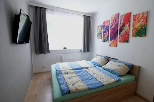 sypialnia z łóżkiem z poduszkami i telewizorem w obiekcie Ostrava, byt 80 m2 v RD w Ostravie