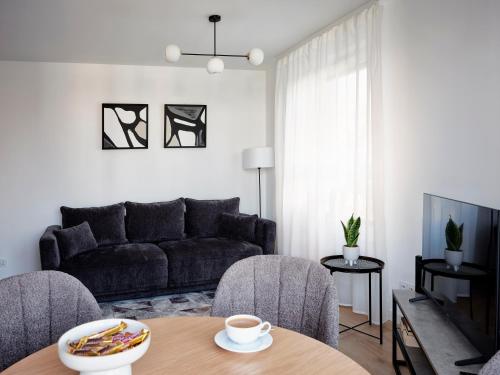 a living room with a couch and a table at A&W Apartament Zatoka Zwycięstwa - Rokosowo in Koszalin