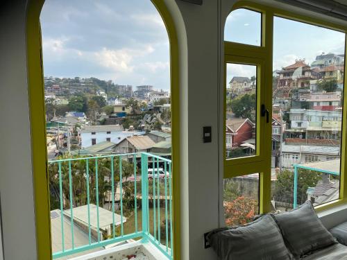 a room with two windows and a view of a city at Homestay BỒ CÔNG ANH in Da Lat