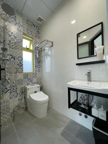 a bathroom with a toilet and a sink and a mirror at Homestay BỒ CÔNG ANH in Da Lat