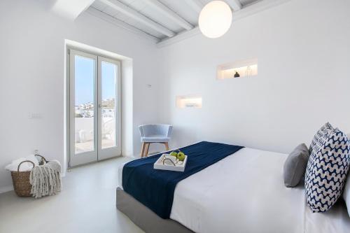 ein Schlafzimmer mit einem Bett, einem Stuhl und einem Fenster in der Unterkunft Breathtaking 6 Bed in Platis Gialos in Platis Gialos
