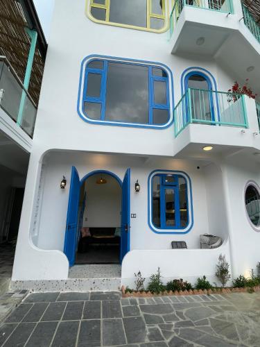 a house with blue doors and a balcony at Homestay BỒ CÔNG ANH in Da Lat
