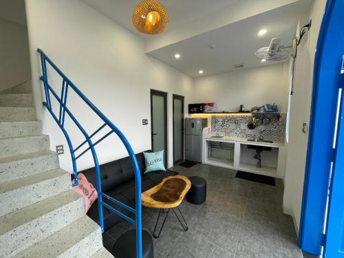 a living room with a staircase and a kitchen at Homestay BỒ CÔNG ANH in Da Lat