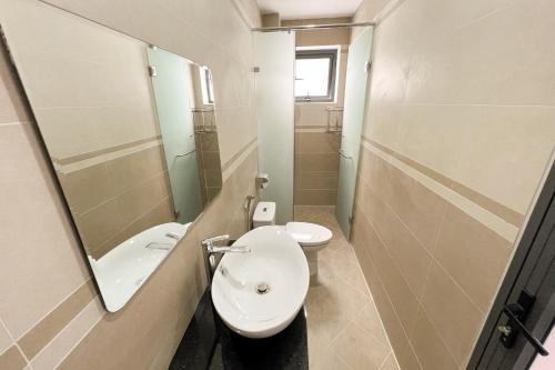 uma casa de banho com um WC, um lavatório e um espelho. em Villa Trung Nghĩa 36 em Ấp Ða Lợi