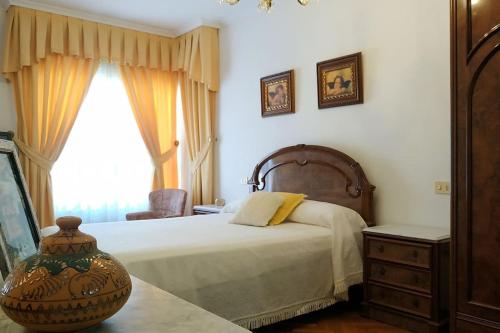a bedroom with a large bed and a window at Piso espacioso en el centro con plaza de garage in Ribeira