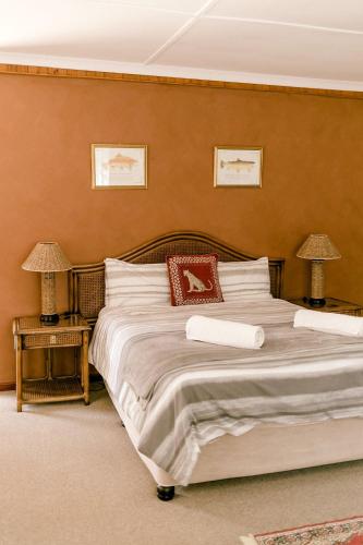 a bedroom with a large bed with two tables and two lamps at Thatchings Bed and Breakfast in Nottingham Road