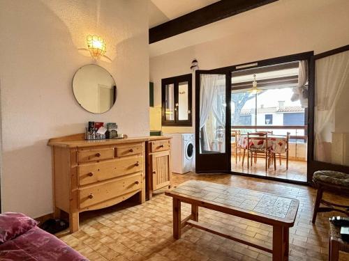- un salon avec une commode en bois et une table dans l'établissement Appartement avec piscine, tennis, proche mer, calme, parking privé - Argelès-sur-Mer - FR-1-225-714, à Argelès-sur-Mer
