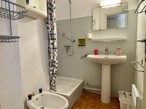 La salle de bains est pourvue d'un lavabo, d'une baignoire et de toilettes. dans l'établissement Appartement avec piscine, tennis, proche mer, calme, parking privé - Argelès-sur-Mer - FR-1-225-714, à Argelès-sur-Mer