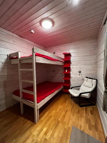 Zimmer mit 2 Etagenbetten und einem Stuhl in der Unterkunft Ruka Cottage in Kuusamo