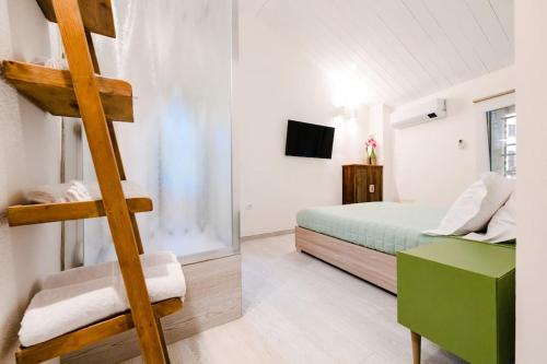 a bedroom with a green bed and a ladder at Casa Quattordici in Cesena