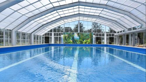 a swimming pool in a building with a large window at La Posta Hotel de Campo in Tres Lomas