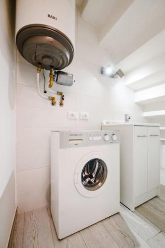 a washer and dryer in a white laundry room at Casa Quattordici in Cesena