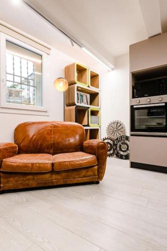 a brown leather couch sitting in a living room at Casa Quattordici in Cesena