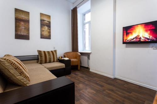 uma sala de estar com um sofá e uma televisão na parede em Pushkinskaya street em Kharkov
