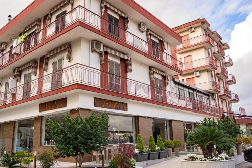 ein Apartmenthaus mit roten Balkonen und Bäumen in der Unterkunft HOTEL 1+1 di C.Costabile & f.lli in Pontecagnano