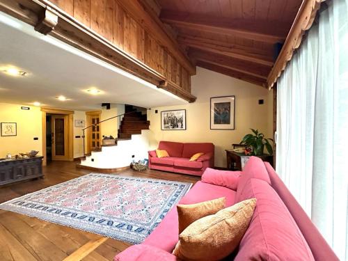 ニュスにあるMaison Rosset agriturismo, CAMERE, appartamenti e spa in Valle d'Aostaのリビングルーム(ピンクのソファ、ラグ付)