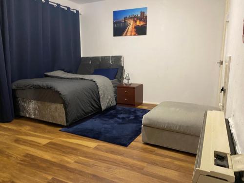 um quarto com uma cama e um repousa-pés em Double En-suite Rooms em Nevendon