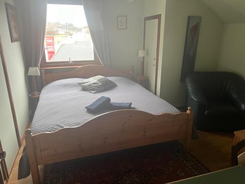 a bedroom with a wooden bed with a window at Stop at The Cross in Borås