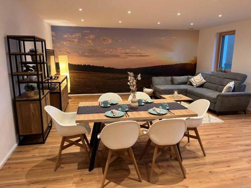 a living room with a table and chairs and a couch at Ferienwohnung Naturraum in Losheim