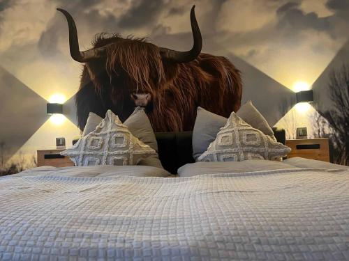 a bedroom with a bed with a bull on the wall at Ferienwohnung Naturraum in Losheim