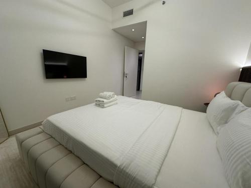 een witte slaapkamer met een bed en een bank bij Luxury Apartment Burj Crown Burj Khalifa View in Dubai