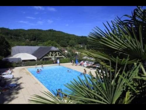 une grande piscine avec des personnes assises autour de celle-ci dans l'établissement chalets19hameauxduperrier.com, à Lissac-sur-Couze