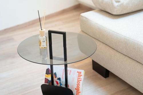 a glass table in a living room next to a couch at NEW modernes Loft im Zentrum von Deggendorf in Deggendorf