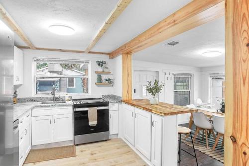 uma cozinha com armários brancos e um forno de fogão preto em Central, Cozy Retreat em Vero Beach