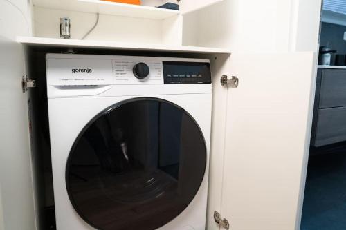 a white washing machine in a white cabinet at NEW modernes Loft im Zentrum von Deggendorf in Deggendorf