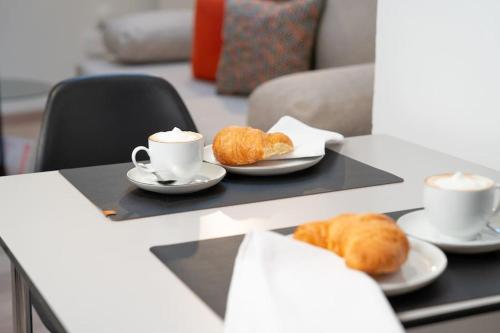 a table with two cups of coffee and croissants at NEW modernes Loft im Zentrum von Deggendorf in Deggendorf