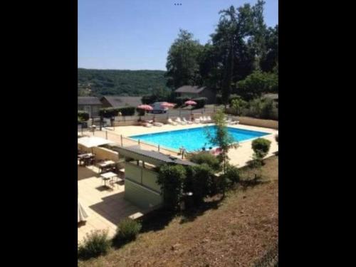 une grande piscine avec chaises et parasols dans l'établissement chalets19hameauxduperrier.com, à Lissac-sur-Couze