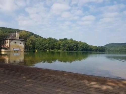 un grand lac avec un bâtiment au milieu dans l'établissement chalets19hameauxduperrier.com, à Lissac-sur-Couze