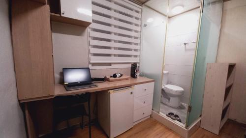 a bathroom with a desk with a laptop computer on it at Haechi Stay GuestHouse - For foreigners only in Seoul